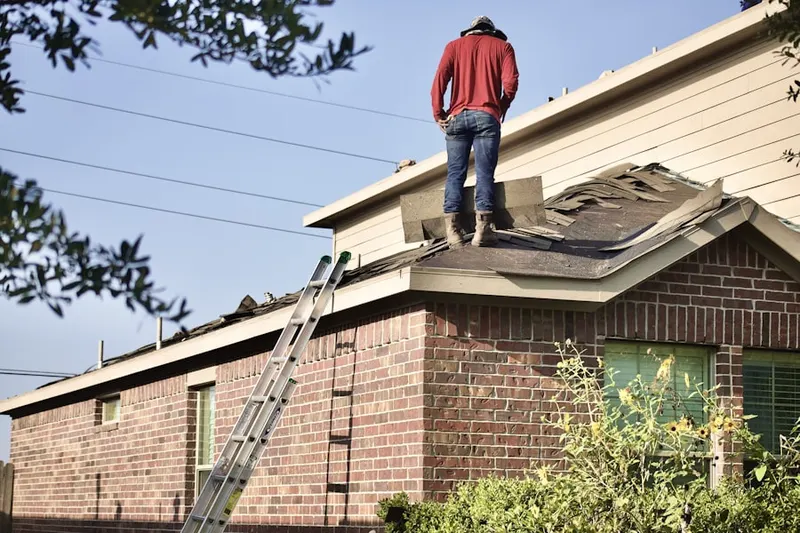 Professional roofer working on a residential roof in Fredon